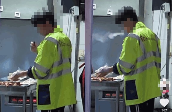 호식이두마리치킨 매장에서 한 직원이 전자담배를 피우며 닭을 조리하고 있다. /사진=인터넷커뮤니티